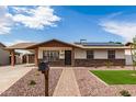 Welcoming single-story home boasting solar panels, brick detailing and low maintenance landscaping at 126 E Mclellan Rd, Mesa, AZ 85201