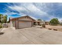 Spacious driveway leading to a two-car garage, complemented by desert landscaping and ample parking space at 1332 E Redfield Rd, Tempe, AZ 85283
