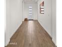 The bright hallway features wood-look tile flooring and a modern front door at 14587 W Alexandria Way, Surprise, AZ 85379