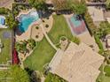 Aerial view of backyard with pool, sport court, patio, desert landscaping, and mature trees at 14655 S 25Th Way, Phoenix, AZ 85048