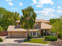 Charming two-story home with desert landscaping, a well-manicured lawn, a three-car garage, and a tile roof at 14655 S 25Th Way, Phoenix, AZ 85048