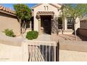 Inviting front entrance with covered porch, security door, mature trees, and desert landscaping at 17911 N Adobe Mesa Ct, Surprise, AZ 85374