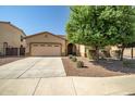 Charming single-Gathering home with a two-car garage, desert landscaping and mature shade tree in the front yard at 17985 W Ivy Ln, Surprise, AZ 85388