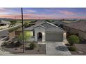 Charming single-Gathering home showcasing desert landscaping, tile roof, and neutral tones against a beautiful desert sunset at 19203 W Jackson St, Buckeye, AZ 85326
