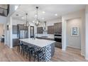 Gourmet kitchen with a large island, stainless steel appliances, modern pendant lights, and lots of storage at 22771 N 98Th Dr, Peoria, AZ 85383