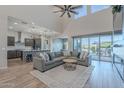 Spacious living room with large windows, natural light, and view of gourmet kitchen and outdoor patio at 22771 N 98Th Dr, Peoria, AZ 85383