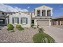 Front yard with desert landscaping, and a home with two-car garage, and two-story architecture at 22960 N 94Th Ln, Peoria, AZ 85383
