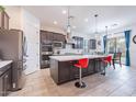 Modern kitchen featuring a large island with seating, stainless steel appliances, and tiled floors at 22960 N 94Th Ln, Peoria, AZ 85383