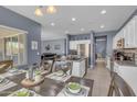 Open-concept kitchen with stainless steel appliances and a large island flows into a dining area, perfect for gatherings at 2322 E Mews Rd, Gilbert, AZ 85298