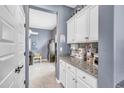 Organized butler's pantry offers ample storage with granite counters and white cabinets for kitchen essentials at 2322 E Mews Rd, Gilbert, AZ 85298