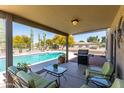 Inviting covered patio with comfortable seating, BBQ, and views of the backyard pool at 25606 W Satellite Ln, Buckeye, AZ 85326