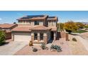 Inviting two-story home featuring a tile roof, desert landscaping, and a two-car garage at 25606 W Satellite Ln, Buckeye, AZ 85326