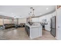 Open-concept kitchen featuring a large island, stainless steel appliances, and seamless flow to the living room at 2822 E Hidalgo Ave, Phoenix, AZ 85040