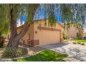 Charming single-story home features a two-car garage and a mature shade tree at 30266 N Royal Oak Way, San Tan Valley, AZ 85143