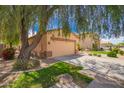 Charming single-story home features a two-car garage and a mature shade tree at 30266 N Royal Oak Way, San Tan Valley, AZ 85143