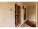 Close-up of unit's front door showing a detailed wooden door with a window to the right at 3119 W Cochise Dr # 111, Phoenix, AZ 85051