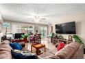 Cozy living room with tile floors, comfortable seating, TV, ceiling fan, and sliding door to outside at 3237 W Angela Dr, Phoenix, AZ 85053