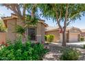 Exterior home view showcasing mature landscaping, partial view of the three-car garage, and charming curb appeal at 3519 E Bridgeport Pkwy, Gilbert, AZ 85295
