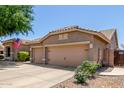 Home exterior showcasing a three-car garage, desert landscaping, and a well-maintained driveway at 3519 E Bridgeport Pkwy, Gilbert, AZ 85295