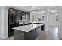 Modern kitchen featuring black cabinets, stainless steel appliances and a large island with stone countertop at 3687 E Leslie Dr, Gilbert, AZ 85296