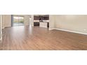 Spacious open-concept living room and kitchen area featuring wood-look tile flooring and neutral paint at 42213 W Santa Fe St, Maricopa, AZ 85138