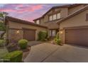 Two-story home featuring a three-car garage, stone accents, and manicured landscaping enhancing curb appeal at 704 E Gemini Pl, Chandler, AZ 85249