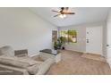 Cozy living room with neutral walls, carpet flooring, ceiling fan, and comfortable seating at 7346 E Naranja Ave, Mesa, AZ 85209