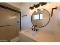 Modern bathroom featuring a glass-enclosed shower and stylish round mirror above the vanity at 749 E Montebello Ave # 231, Phoenix, AZ 85014