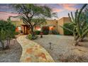 Charming single-story home featuring a stone walkway, desert landscaping and inviting entrance at 8526 E Hackamore Dr, Scottsdale, AZ 85255