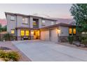 Charming home with a three-car garage, desert landscaping, and a welcoming front porch at sunset at 9231 W Bent Tree Dr, Peoria, AZ 85383