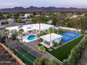 Expansive estate featuring a pool, tennis court, basketball court, and cabana, all set against a mountain backdrop at 9733 E Clinton St, Scottsdale, AZ 85260