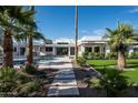 A private backyard oasis showcasing a sparkling pool, lush lawn, and meticulously landscaped garden with palm trees at 9733 E Clinton St, Scottsdale, AZ 85260