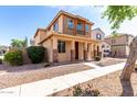 Charming two-story home featuring a cozy front porch and manicured landscaping at 10055 E Isabella Ave, Mesa, AZ 85209