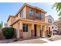 Charming two-story home featuring a cozy front porch and manicured landscaping at 10055 E Isabella Ave, Mesa, AZ 85209