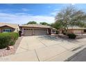 Attractive one-story home showcasing a three-car garage and landscaped front yard at 11034 W Sierra Pinta Dr, Peoria, AZ 85373