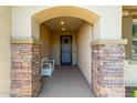 Inviting front porch with stone pillars, a bench, and a view of the home's entry door and exterior at 1277 W Stephanie Ln, San Tan Valley, AZ 85143