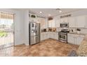 Bright, modern kitchen with stainless steel appliances, white cabinets, granite countertops, and tile flooring at 1277 W Stephanie Ln, San Tan Valley, AZ 85143