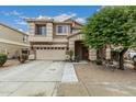 Charming two-story home featuring a well-manicured lawn, a two-car garage, and a welcoming entryway at 14318 N 142Nd Ln, Surprise, AZ 85379