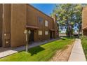 Charming townhouse exterior displays a red-tiled roof, secure front door, and lush green lawn at 16225 N 30Th St # 11, Phoenix, AZ 85032