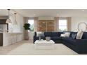 Open-concept living space with a large sectional sofa, modern decor, and seamless flow to the kitchen at 16677 W Chama Dr, Surprise, AZ 85387
