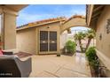 Covered courtyard featuring tiled flooring, seating, and a wrought iron gate at 17718 N Desert Flower Trl, Surprise, AZ 85374