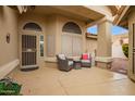 Cozy covered patio with seating, tiled flooring, and a view of the backyard at 17718 N Desert Flower Trl, Surprise, AZ 85374