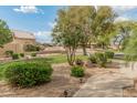 Landscaped front yard with gravel, greenery and desert plants in a quiet neighborhood on a sunny day at 19874 N 90Th Ave, Peoria, AZ 85382