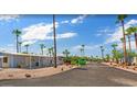 A mobile home neighborhood with palm trees under a clear blue sky with scattered clouds at 200 E Ivanhoe St, Chandler, AZ 85225