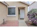 A close-up view showing the front door, window and a colorful flowering bush at 2112 E Donald Dr, Phoenix, AZ 85024