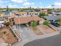 Inviting single-story home with a covered carport, desert landscaping, and mature trees located on a corner lot at 2217 N 51St Ln, Phoenix, AZ 85035