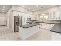 Modern kitchen with white cabinets, stainless appliances, and dark countertops at 25450 W Pueblo Ave, Buckeye, AZ 85326