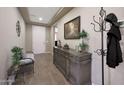 Charming entryway features a hall tree, neutral paint, wood-look tile, and views to the front door at 3359 E Penedes Dr, Gilbert, AZ 85298