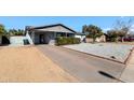 View of the house exterior highlighting the driveway and rock landscaping at 3422 W Poinsettia Dr, Phoenix, AZ 85029