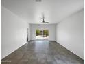 Spacious living room features tile floors, a ceiling fan, and sliding glass doors to the backyard at 35337 W San Alvarez Ave, Maricopa, AZ 85138